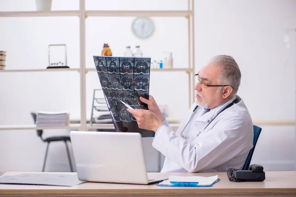 Gammal manlig röntgenläkare som arbetar på kliniken — Stockfoto