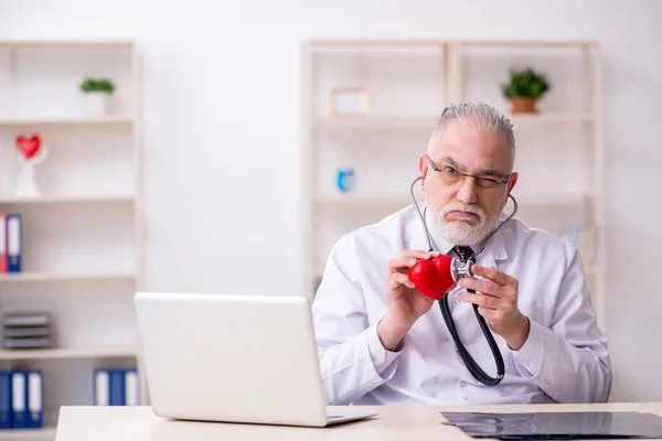 Klinikte çalışan yaşlı bir erkek kardiyolog. — Stok fotoğraf