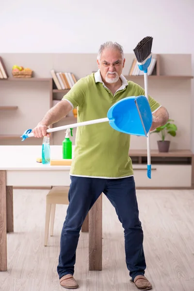 Oude man die het huis schoonmaakt — Stockfoto