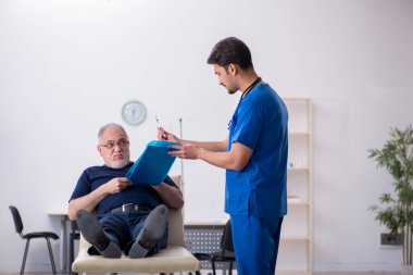 Yaşlı adam genç erkek doktoru ziyaret ediyor.