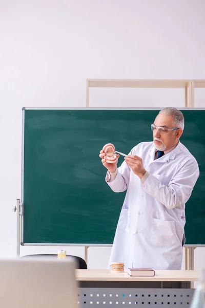 Oude mannelijke tandarts in de klas — Stockfoto