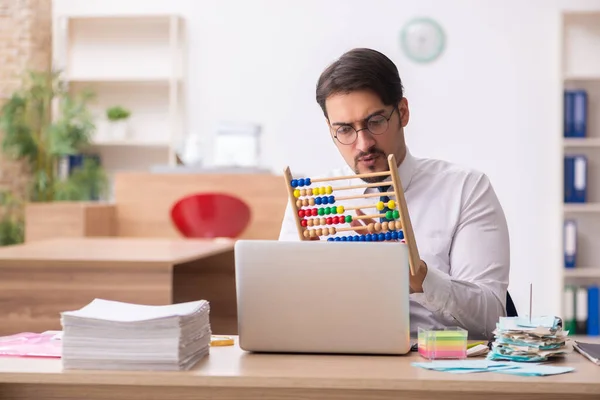 Joven contable masculino en concepto de planificación presupuestaria con ábaco —  Fotos de Stock