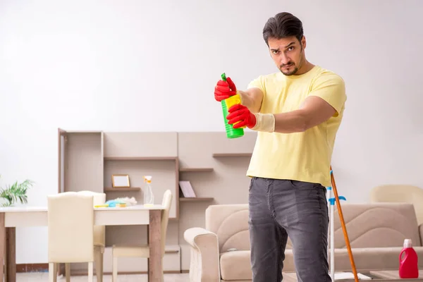 Jovem empreiteiro limpando a casa — Fotografia de Stock