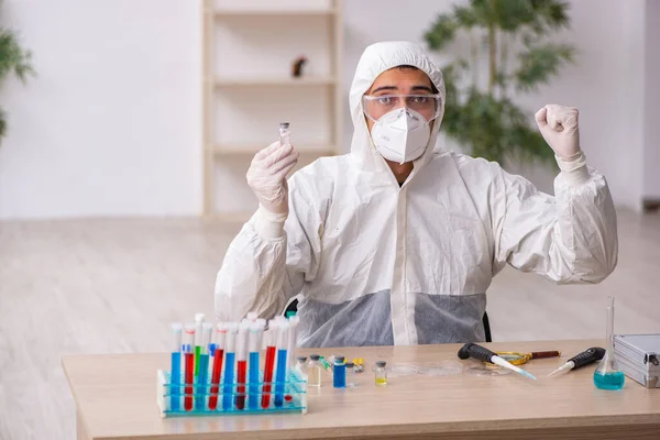 Jeune chimiste masculin travaillant au laboratoire pendant la pandémie — Photo