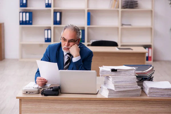 Velho empregado masculino e muito trabalho no escritório — Fotografia de Stock