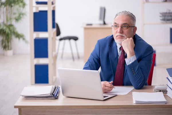 Velho empregado masculino e muito trabalho no escritório — Fotografia de Stock