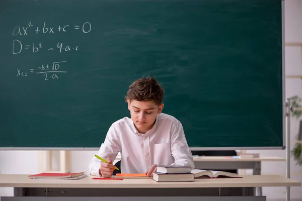 Estudante estudando matemática na frente do quadro negro — Fotografia de Stock