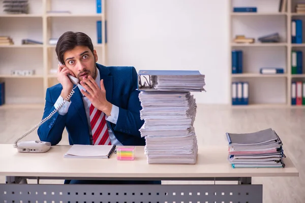 Young businessman employee unhappy with excessive work in the office Stock Picture