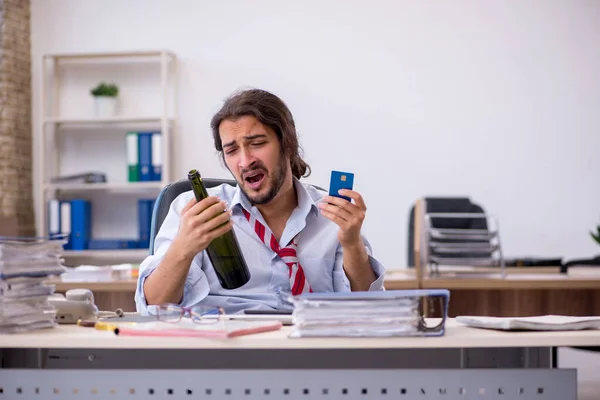 Mladý muž zaměstnanec pití alkoholu v kanceláři — Stock fotografie