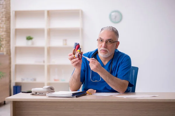 Oude mannelijke cardioloog werkzaam in de kliniek — Stockfoto