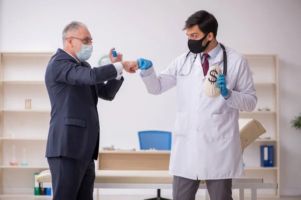 Velho empresário visitando jovem médico do sexo masculino na vacinação concep — Fotografia de Stock