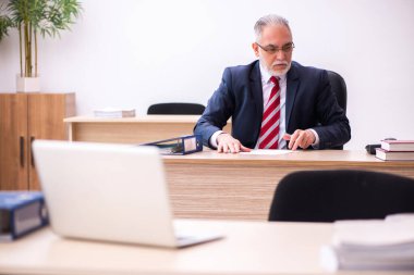 Ofiste oturan eski bir işadamı.