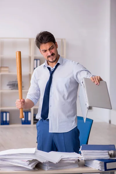 Jovem funcionário masculino infeliz com excesso de trabalho no escritório — Fotografia de Stock