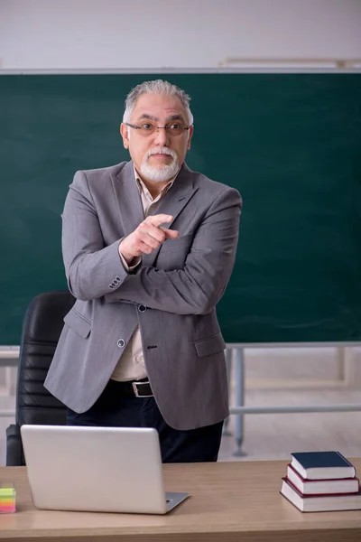 Oude mannelijke leraar voor schoolbord — Stockfoto