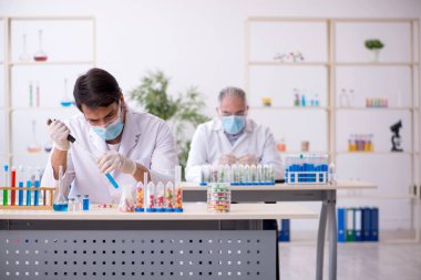 Laboratuvarda uyuşturucu sentezi konseptinde iki erkek kimyager.