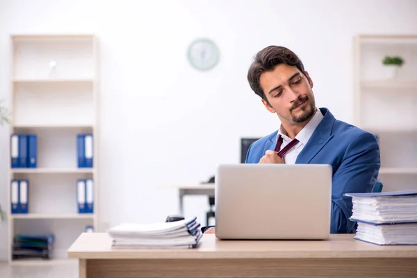 Joven empleado masculino descontento con el trabajo excesivo en la oficina —  Fotos de Stock