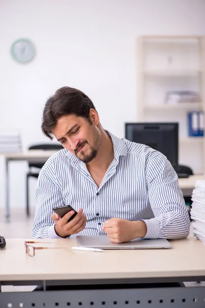 Jeune employé masculin et trop de travail au bureau — Photo