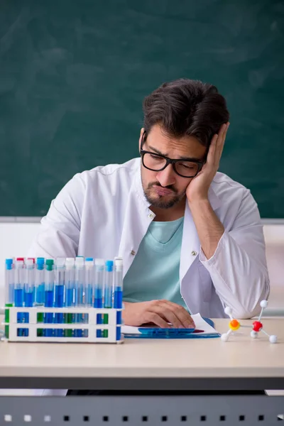 Jonge mannelijke chemicus voor schoolbord — Stockfoto