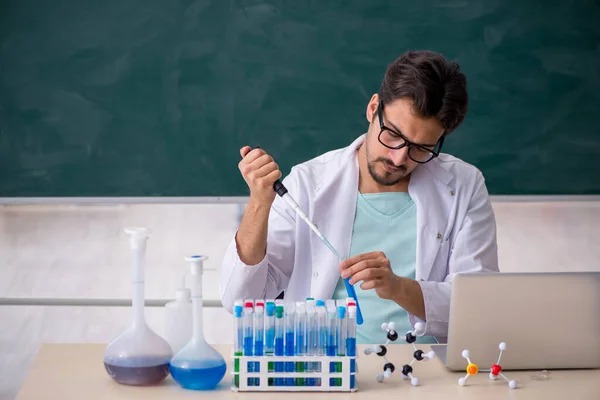 Jonge mannelijke chemicus voor schoolbord — Stockfoto