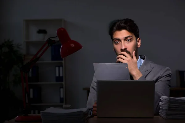 Jovem empregado do sexo masculino que trabalha até tarde no escritório — Fotografia de Stock