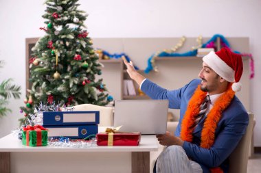 Genç işadamı Noel arifesinde evden çalışıyor.