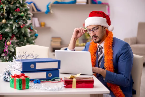 Jovem empresário trabalhando em casa na véspera de Natal — Fotografia de Stock