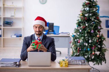 Genç erkek çalışan Noel 'i işyerinde kutluyor