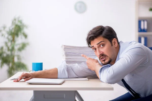 Junge männliche Mitarbeiter und zu viel Arbeit im Büro — Stockfoto