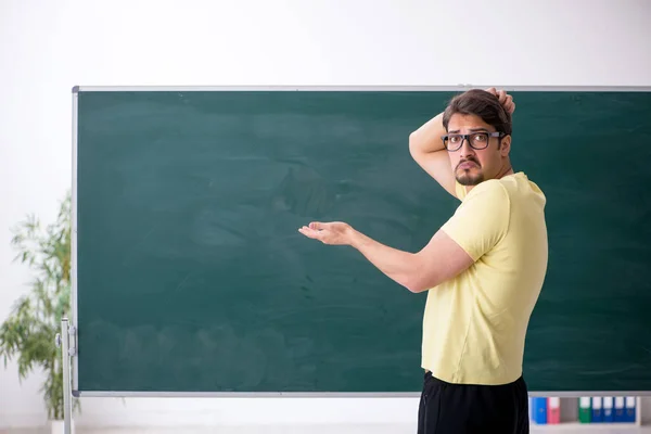 Young male student in front of blackboard — Stock Photo, Image