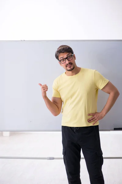 Young male student in front of whiteboard — Stock Photo, Image