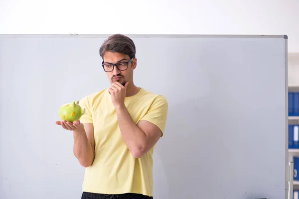 Junge männliche Studenten halten Sparschwein — Stockfoto