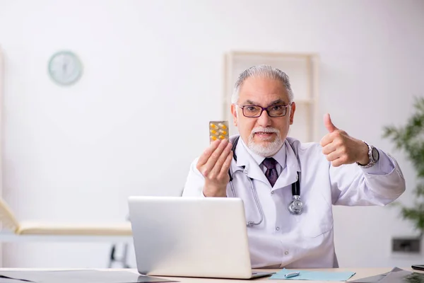 Old male doctor working at the hospital — Stock Photo, Image