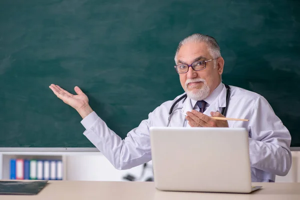 Oude mannelijke dokter leraar voor schoolbord — Stockfoto