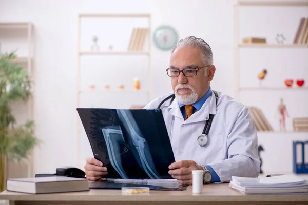 Gammal manlig röntgenläkare som arbetar på kliniken — Stockfoto