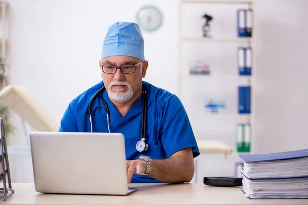 Klinikte çalışan yaşlı erkek doktor. — Stok fotoğraf