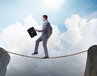 İş adamı iş konseptinde sıkı bir ipin üzerinde yürüyor