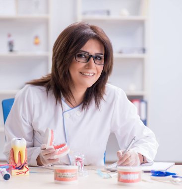 Diş implantı üzerinde çalışan kadın dişçi.