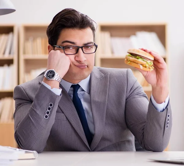 Hungriger, lustiger Geschäftsmann isst Junkfood-Sandwich — Stockfoto