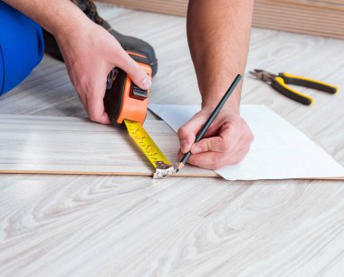 Tamirci evde döşeme kaplaması döşemiş.