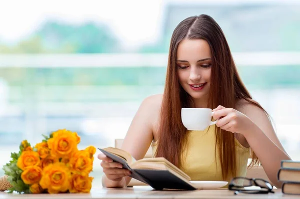 Jeune étudiant buvant du café tout en sucrant — Photo