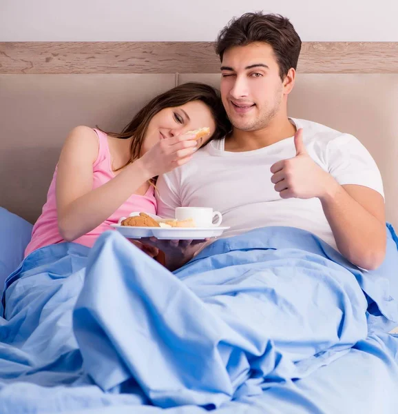 Gelukkig gezin ontbijten op bed — Stockfoto