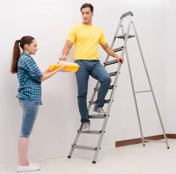 Jovem casal parede de pintura em casa — Fotografia de Stock