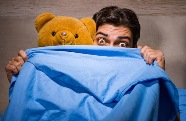 Young man scared in bed