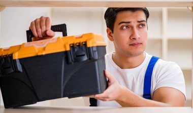 İşçi adam montaj kitaplığını tamir ediyor