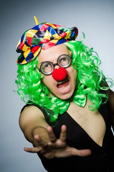 Grappige clown tegen de donkere achtergrond — Stockfoto