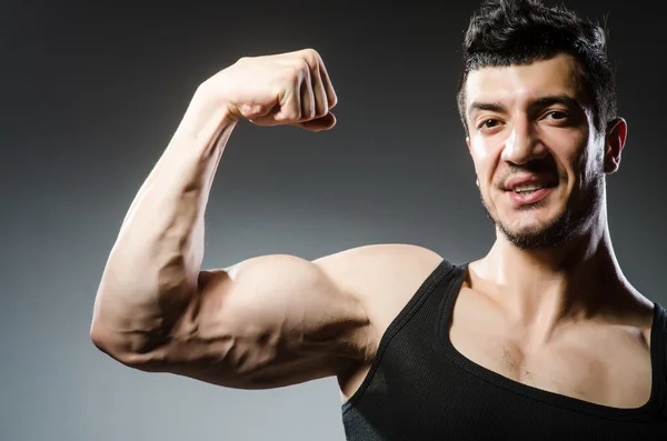 Homem muscular posando em estúdio escuro — Fotografia de Stock