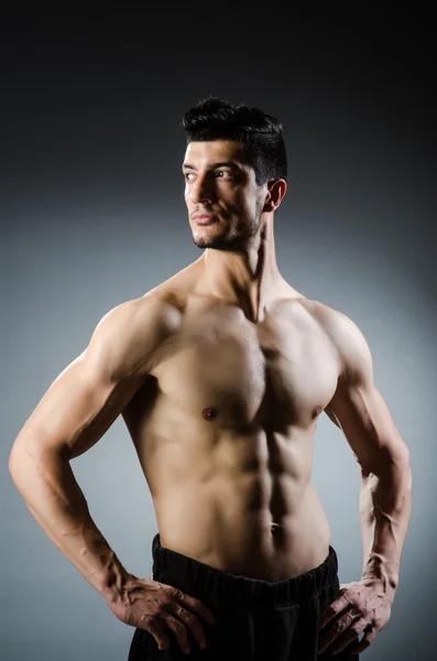 Hombre musculoso posando en estudio oscuro — Foto de Stock