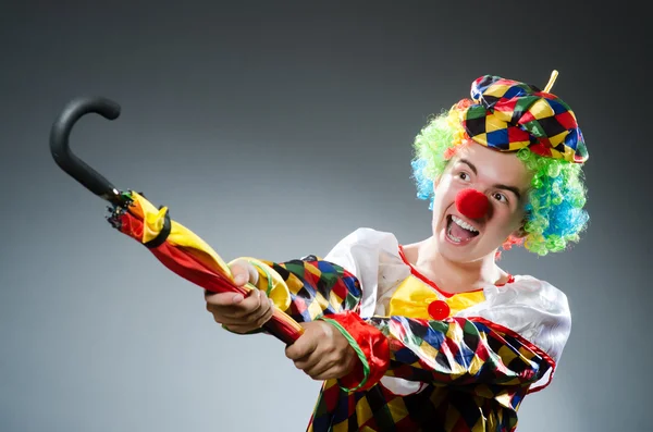 Lustiger Clown mit buntem Regenschirm — Stockfoto