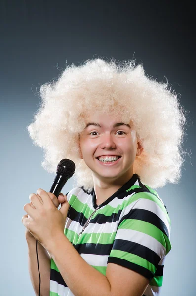 Man in afrowig singing with mic — Stock Photo, Image