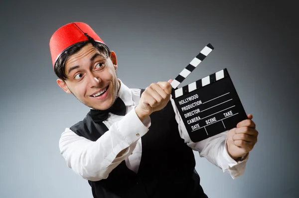 Man with movie board wearing fez hat — Stock Photo, Image